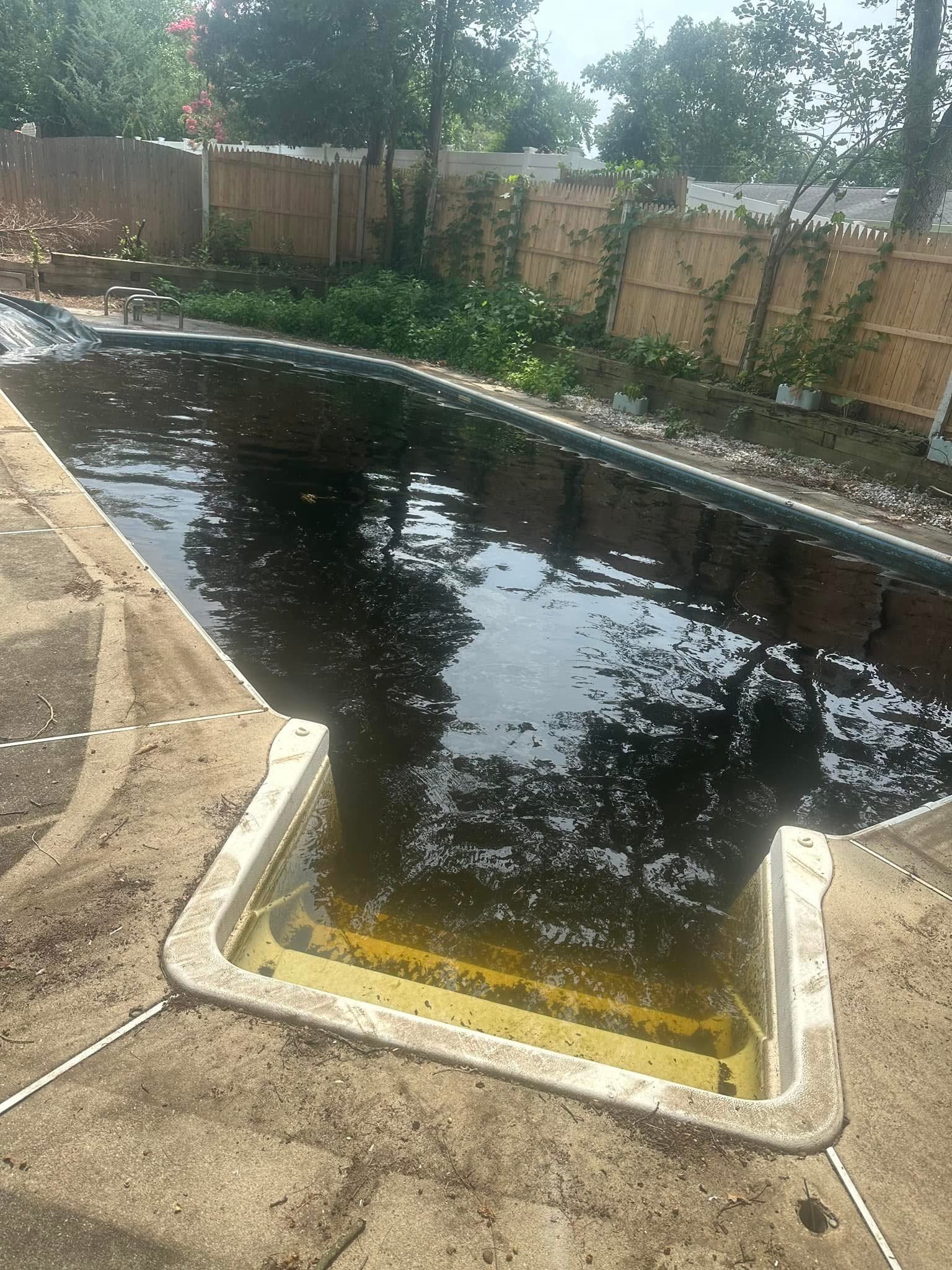 Neglected pool with black swamp water and stained steps