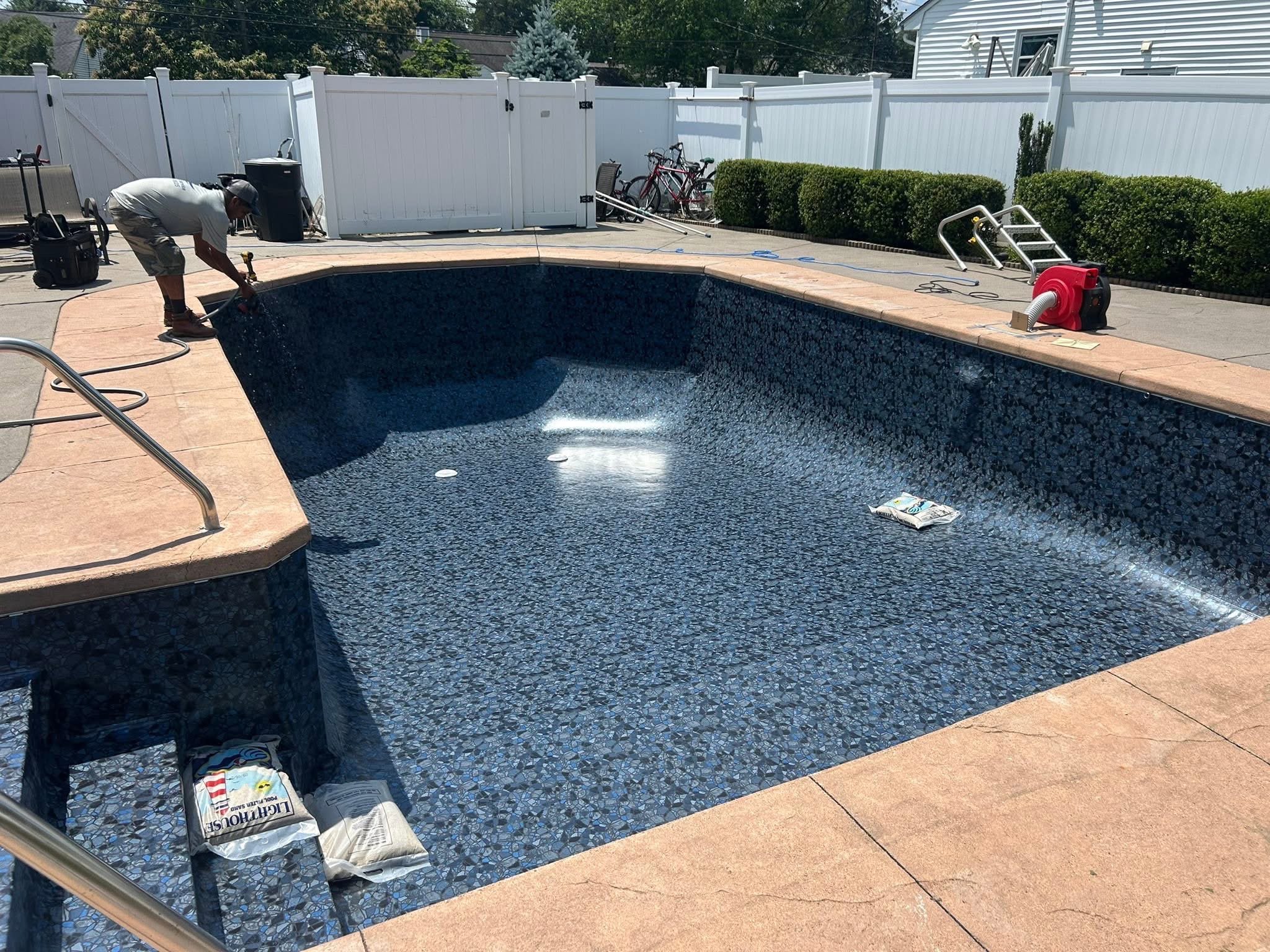 New dark pebble-pattern liner installed and filling with water