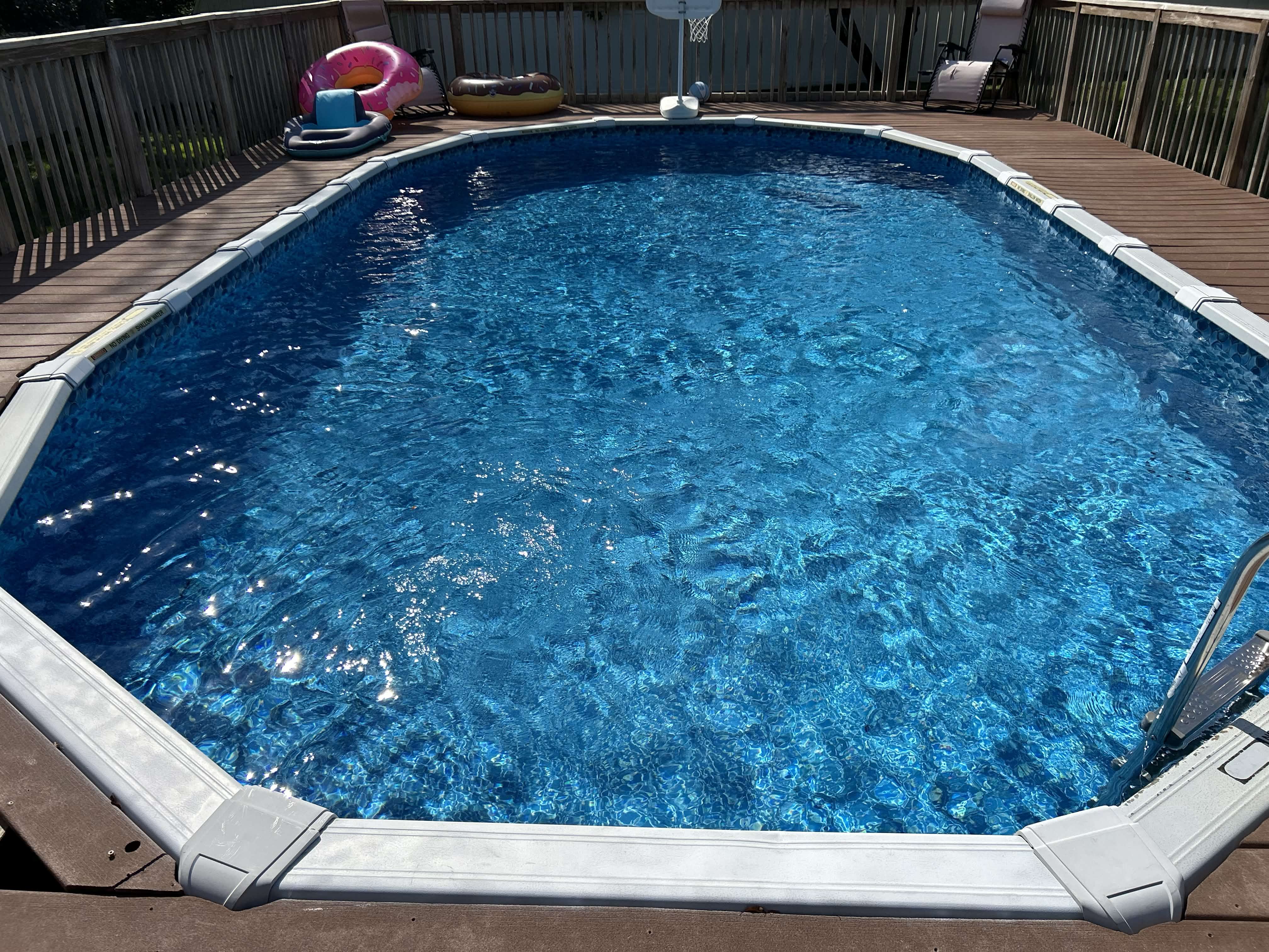 Above ground pool with new blue liner on wood deck